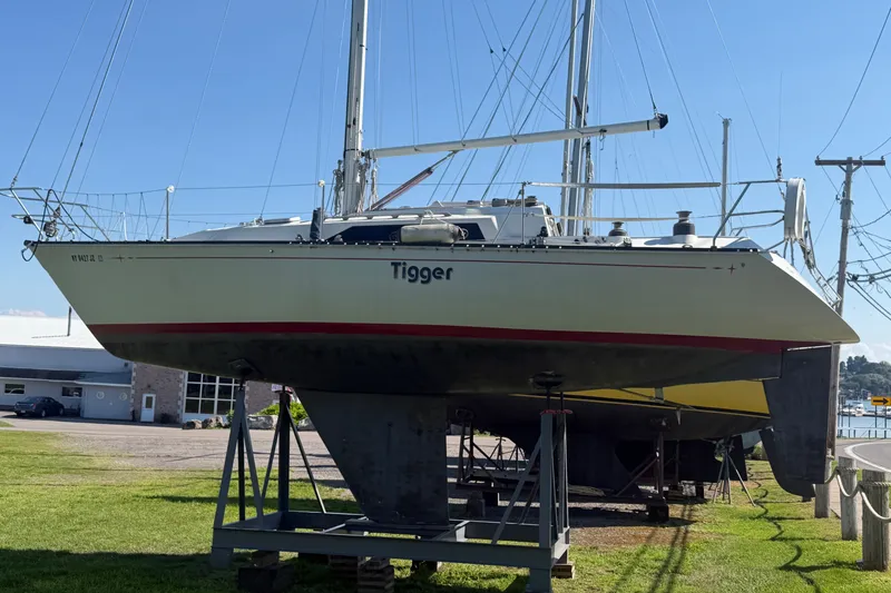 The Image of 1984 C&C 33 MK II sailboat on stands, named "Tigger," in a marina setting. - 0