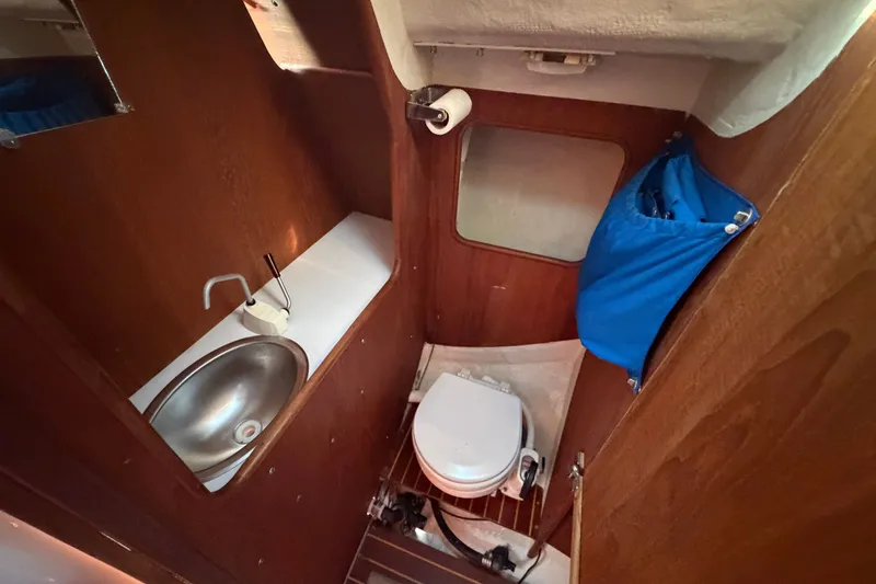 Slide: The Image of 1984 C&C 33 MK II yacht bathroom with sink, toilet, and wooden interior. - 53