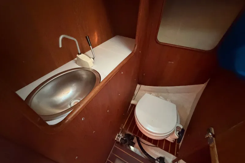 Slide: The Image of 1984 C&C 33 MK II yacht bathroom with sink and toilet, featuring wooden interior. - 58
