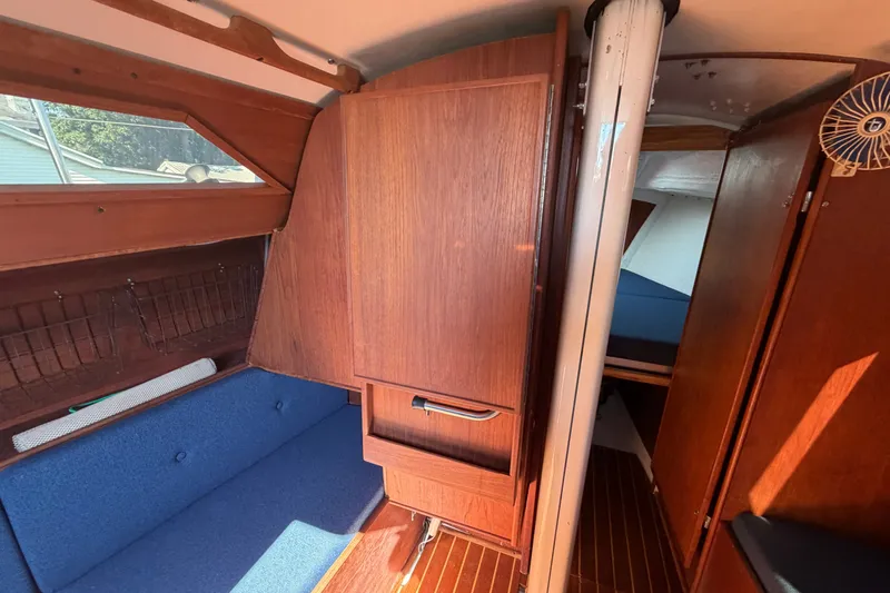 Slide: The Image of Interior of 1984 C&C 33 MK II sailboat with wooden cabinetry and blue seating. - 47