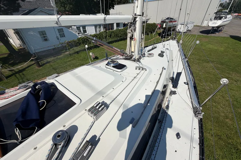 Slide: The Image of 1984 C&C 33 MK II sailboat deck with rigging and winches, docked on grass. - 16