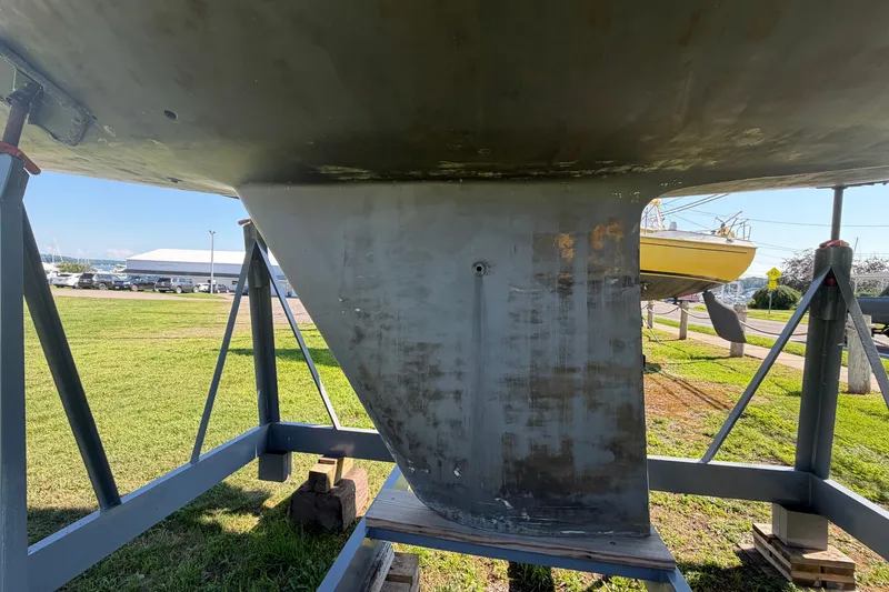 Slide: The Image of 1984 C&C 33 MK II sailboat keel on a stand, outdoor setting. - 2