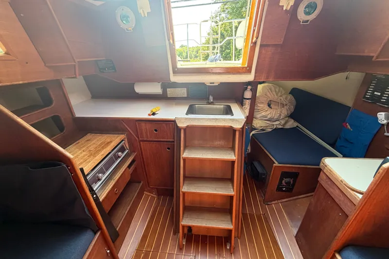 Slide: The Image of Interior of 1984 C&C 33 MK II sailboat with wooden cabinetry and compact kitchen area. - 36