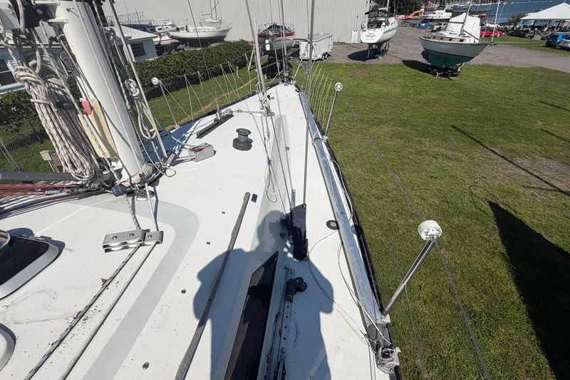 Slide: The Image of 1984 C&C 33 MK II sailboat deck with rigging and winches, docked on grass. - 17