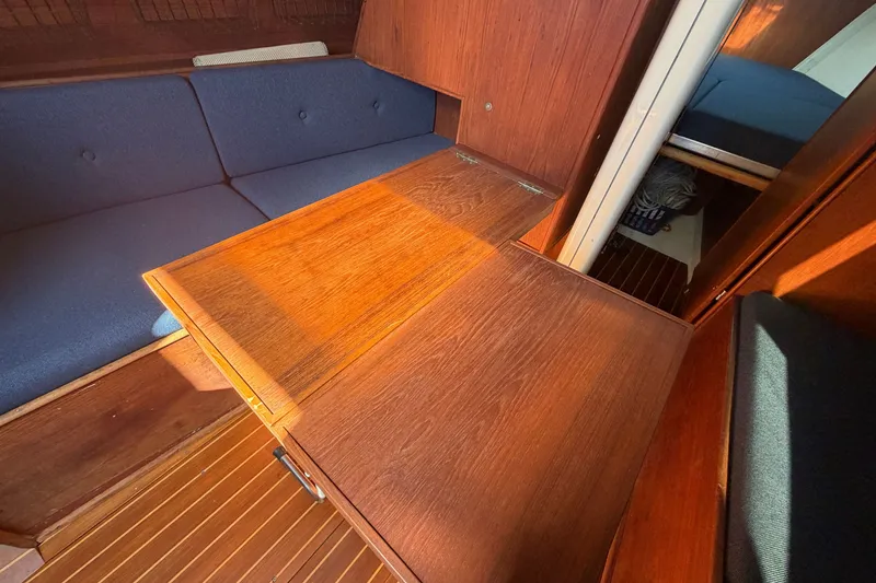 Slide: The Image of Interior of 1984 C&C 33 MK II sailboat with wooden table and blue seating. - 49