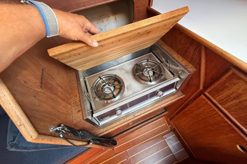 Slide: The Image of 1984 C&C 33 MK II yacht galley with a two-burner stove and wooden cabinetry. - 43