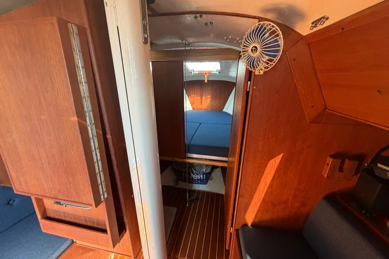 Slide: The Image of Interior of 1984 C&C 33 MK II sailboat with wooden cabinetry and blue cushions. - 50