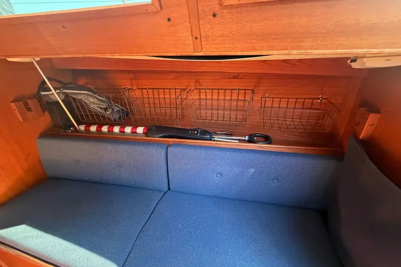 Slide: The Image of Interior of 1984 C&C 33 MK II sailboat with blue cushions and storage baskets. - 45