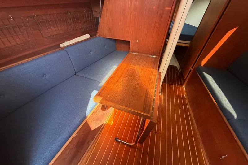Slide: The Image of Interior of 1984 C&C 33 MK II sailboat with wooden table and blue seating. - 48