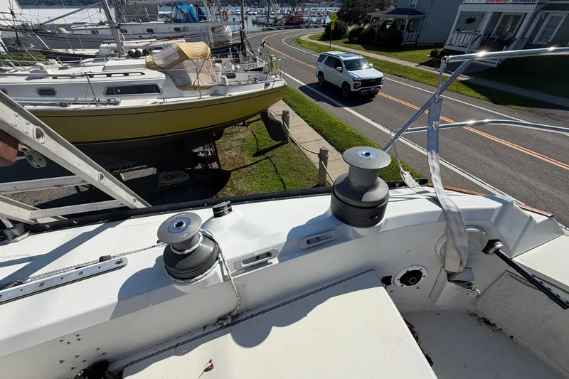 Slide: The Image of 1984 C&C 33 MK II sailboat on land, with winches and nearby road. - 13