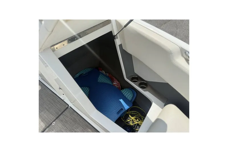 Slide: The Image of Storage compartment in a 2017 Cobalt R3 boat, containing blue mat and ropes. - 12