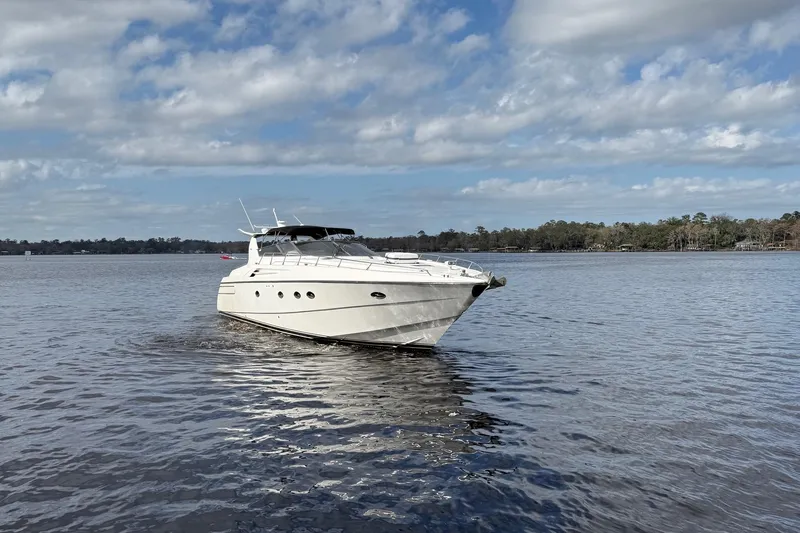 Slide: The Image of 1994 Sunseeker Camargue 55 yacht cruising on a calm lake under a partly cloudy sky. - 3