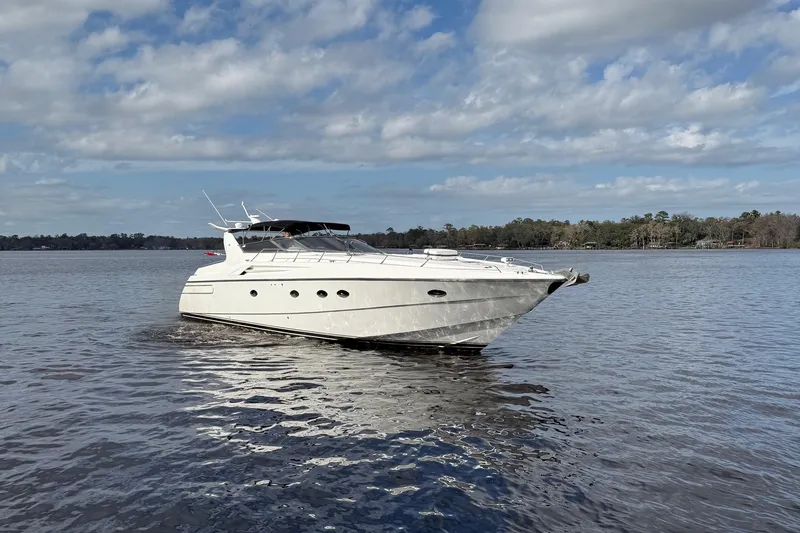 Slide: The Image of Sunseeker Camargue 55 yacht from 1994 on a calm lake under a cloudy sky. - 21