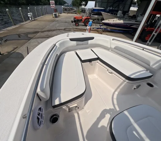 Slide: The Image of The image shows the bow area of a Robalo Explorer R202EX boat with white seating and a table. - 17