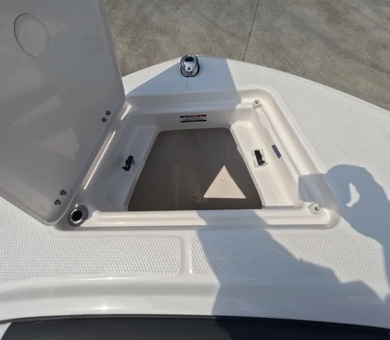 Slide: The Image of An open storage compartment on a boat with textured deck and a silver fitting. - 24