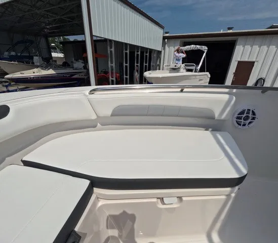Slide: The Image of The image shows the seating area of a 2027 Robalo Explorer R202EX boat at a marina. - 21