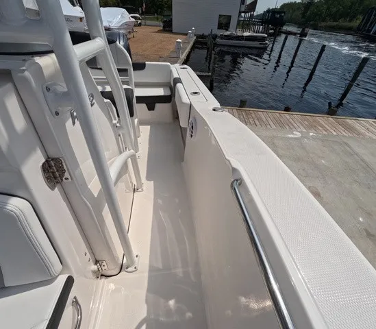 Slide: The Image of The image shows the deck of a 2027 Robalo Explorer R202EX boat docked by the water. - 28