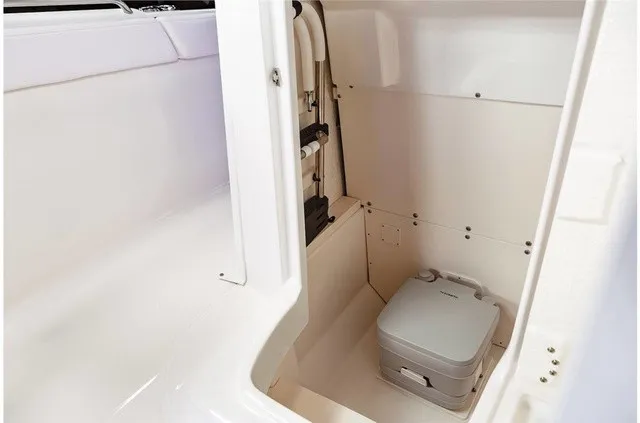 Slide: The Image of The image shows a compact, clean boat toilet with a portable toilet in a white enclosure. - 20