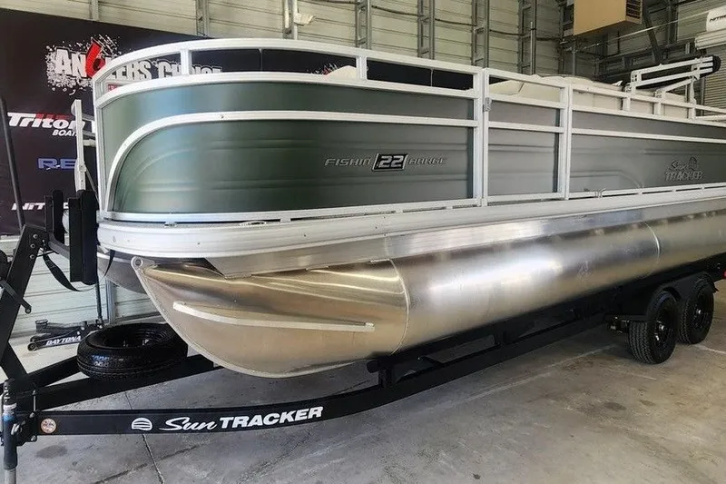 Slide: The Image of 2027 Sun Tracker Fishin' Barge 22 DLX pontoon boat on trailer in garage. - 14