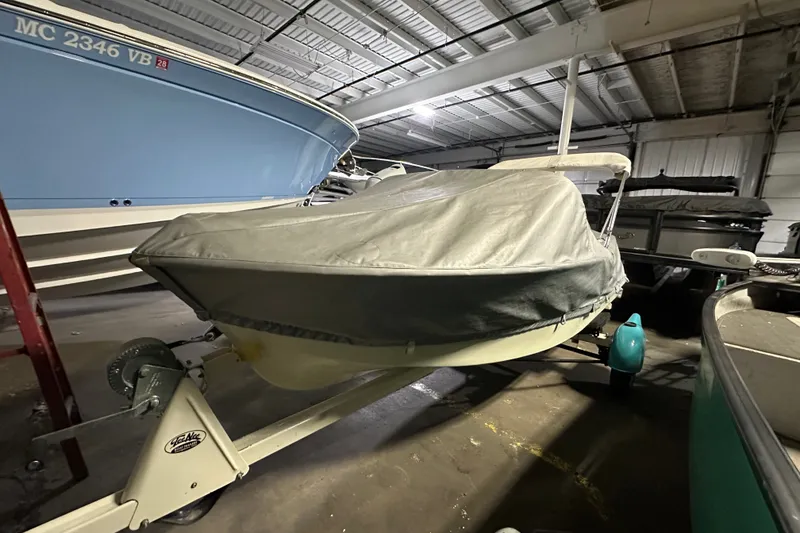 Slide: The Image of 1959 Seafury 14' Antique boat covered in storage, alongside other vessels. - 2