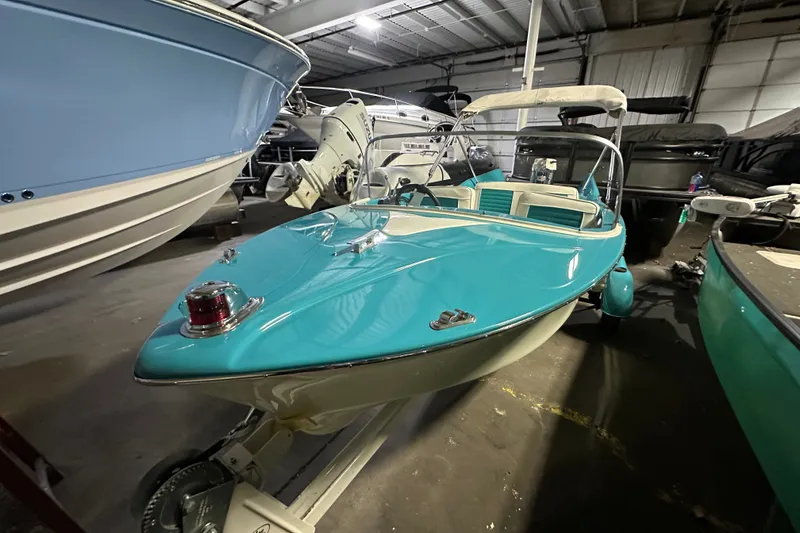 Slide: The Image of 1959 Seafury 14' Antique boat with turquoise and white design in a storage facility. - 4
