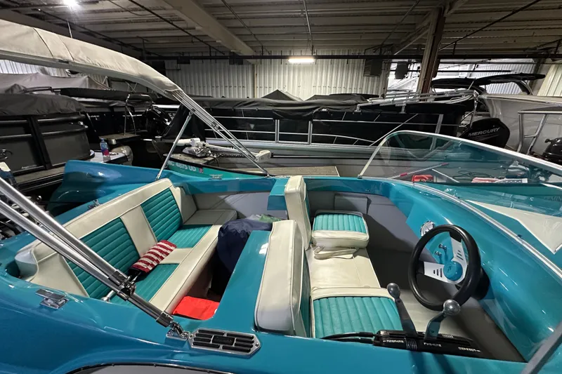 Slide: The Image of 1959 Seafury 14' Antique boat with teal and white interior in a storage facility. - 7