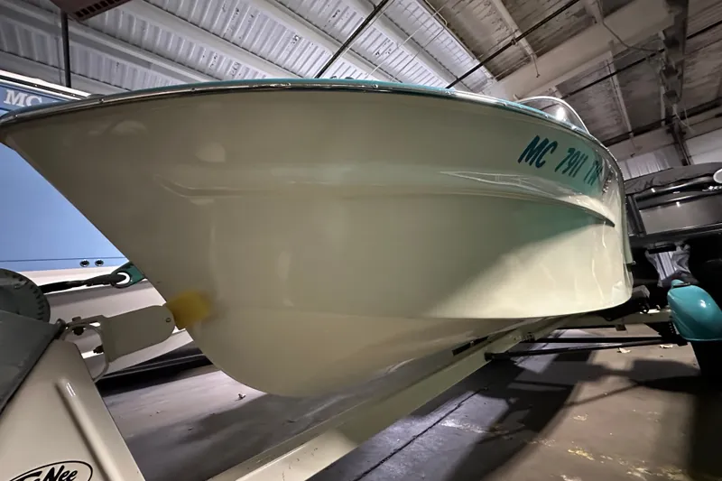 Slide: The Image of 1959 Seafury 14' Antique boat in a garage, showcasing its classic design and sleek hull. - 5