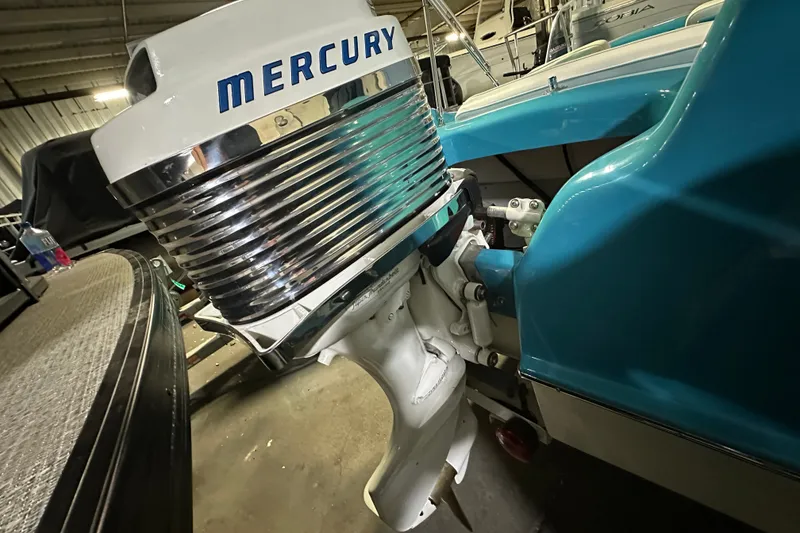 Slide: The Image of 1959 Seafury 14' Antique boat with Mercury outboard motor in a garage setting. - 11