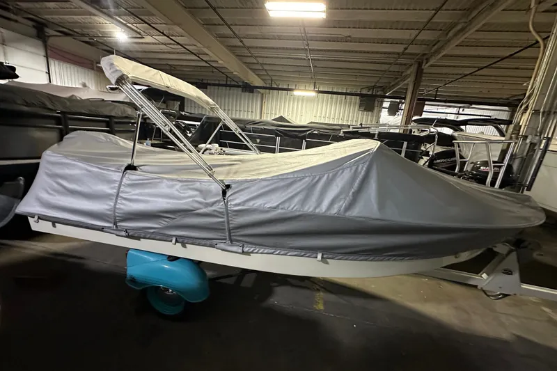 Slide: The Image of 1959 Seafury 14' Antique boat covered in a garage, showcasing classic design. - 1