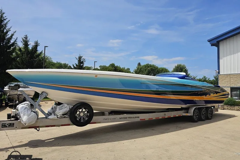 Slide: The Image of 2010 Nor-Tech 4300V powerboat on trailer, vibrant blue and yellow design. - 23