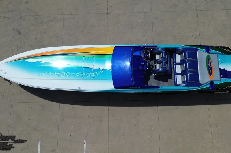 Slide: The Image of Overhead view of a 2010 Nor-Tech 4300V speedboat with vibrant blue and green design. - 39