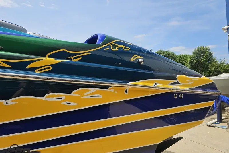 Slide: The Image of 2010 Nor-Tech 4300V boat with vibrant blue, yellow, and green graphics under a clear sky. - 29