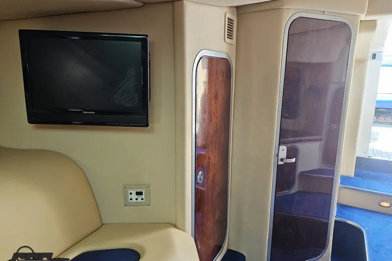 Slide: The Image of Interior of 2010 Nor-Tech 4300V boat featuring TV and wooden cabinetry. - 88