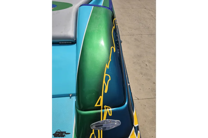 Slide: The Image of Colorful 2010 Nor-Tech 4300V boat with vibrant green and blue design. - 57