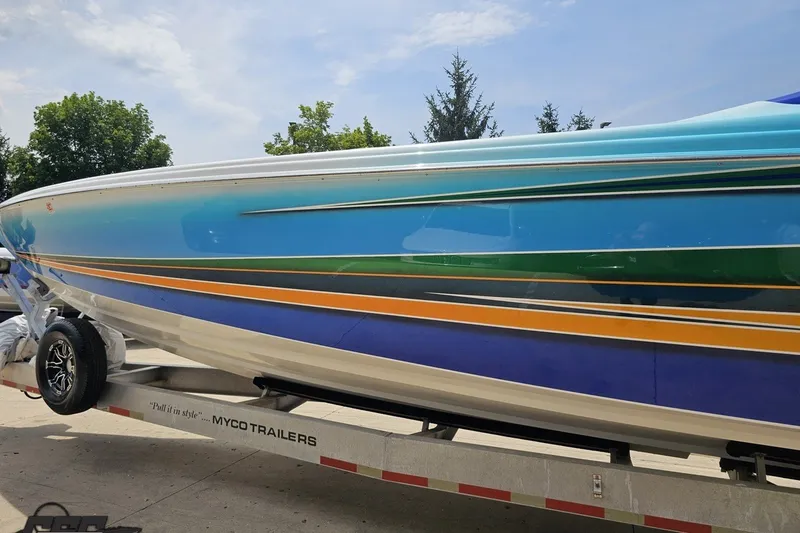Slide: The Image of 2010 Nor-Tech 4300V boat with vibrant blue and orange stripes on a trailer. - 31