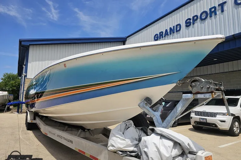 Slide: The Image of 2010 Nor-Tech 4300V boat on trailer at Grand Sport Center, vibrant blue and white design. - 18