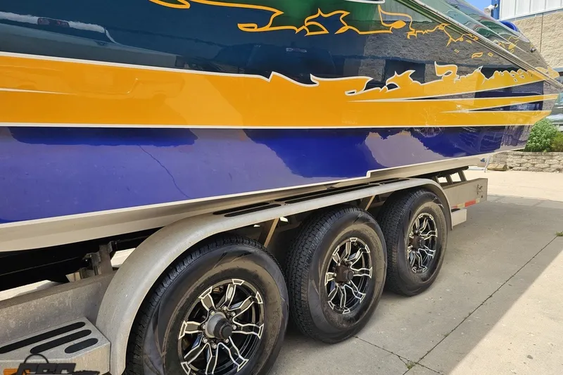 Slide: The Image of 2010 Nor-Tech 4300V boat on trailer with vibrant blue and yellow design. - 28
