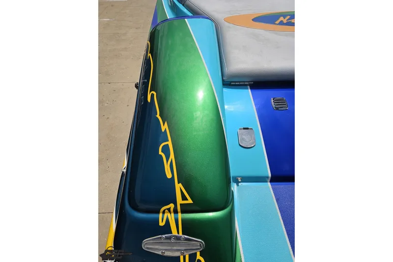 Slide: The Image of Colorful 2010 Nor-Tech 4300V boat with vibrant green and blue detailing. - 56