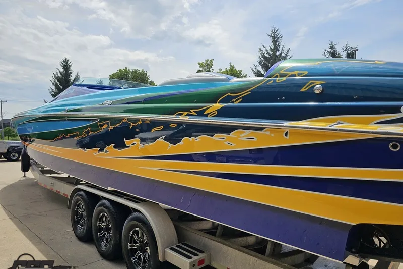 Slide: The Image of Colorful 2010 Nor-Tech 4300V boat on trailer, showcasing vibrant graphics and sleek design. - 32