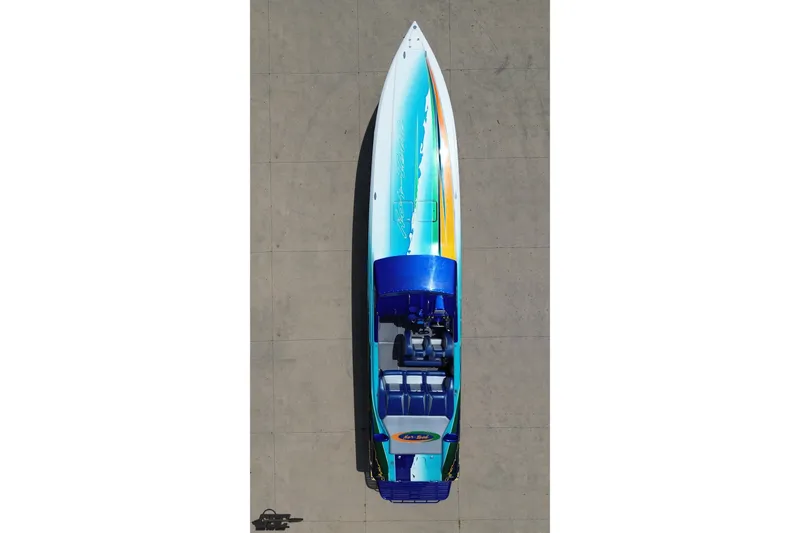 Slide: The Image of Overhead view of a 2010 Nor-Tech 4300V speedboat with vibrant blue and white design. - 42