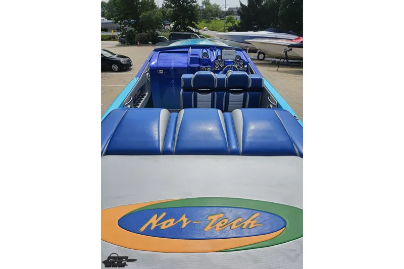 Slide: The Image of 2010 Nor-Tech 4300V powerboat with blue seating and dashboard, parked outdoors. - 52