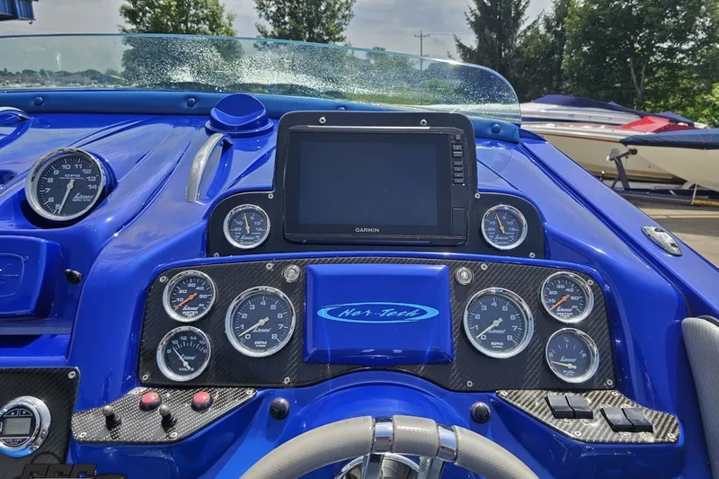 Slide: The Image of Dashboard of a 2010 Nor-Tech 4300V boat with gauges and Garmin display. - 73