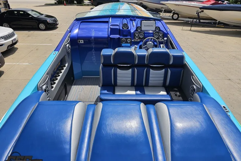 Slide: The Image of 2010 Nor-Tech 4300V boat interior with blue seating and advanced dashboard controls. - 58