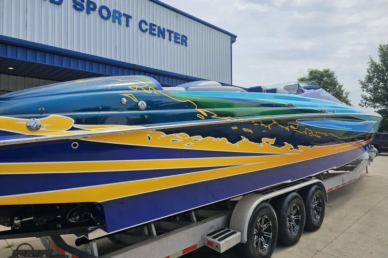 Slide: The Image of 2010 Nor-Tech 4300V powerboat with vibrant blue and yellow design on a trailer. - 14