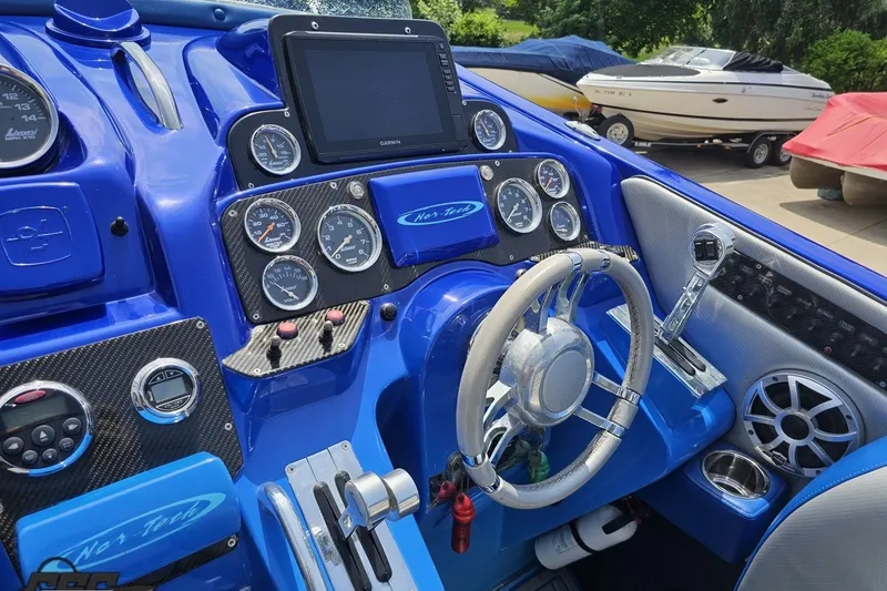 Slide: The Image of Cockpit of a 2010 Nor-Tech 4300V boat with blue dashboard and steering wheel. - 71