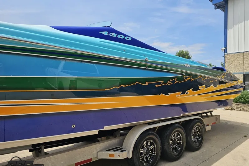Slide: The Image of Colorful 2010 Nor-Tech 4300V boat on trailer, vibrant design and sleek profile. - 26
