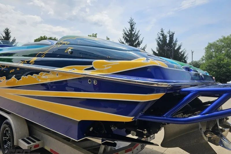 Slide: The Image of Colorful 2010 Nor-Tech 4300V boat with vibrant graphics on a trailer. - 33