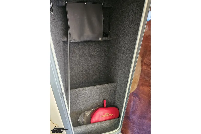 Slide: The Image of Interior storage compartment of 2010 Nor-Tech 4300V boat with red safety equipment. - 90