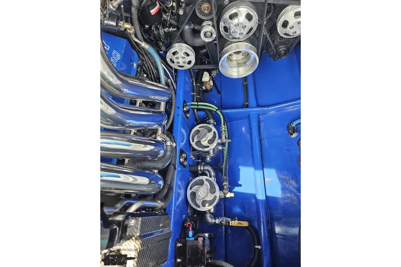 Slide: The Image of Engine components of a 2010 Nor-Tech 4300V boat, featuring polished metal and blue accents. - 104