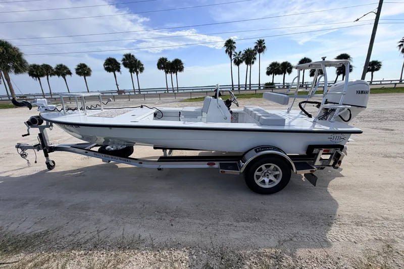 Slide: The Image of 2021 Hell's Bay Marathon boat on trailer, parked near palm trees and waterfront. - 4